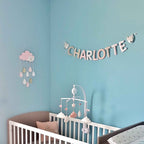 Guirlande prénom en tissu pastel avec embouts renard, exemple « Charlotte », sur un mur bleu canard de chambre de bébé fille