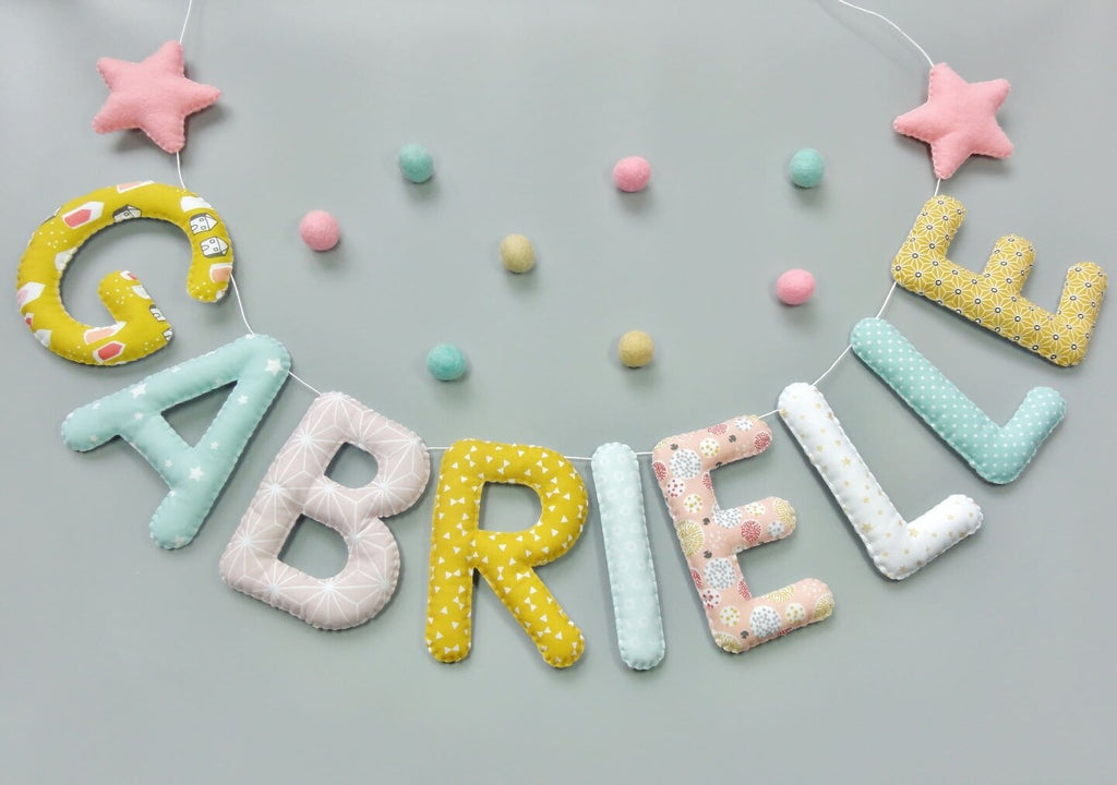 Guirlande prénom en tissu pastel menthe, moutarde et rose avec étoiles et pompons, exemple « Gabrielle »