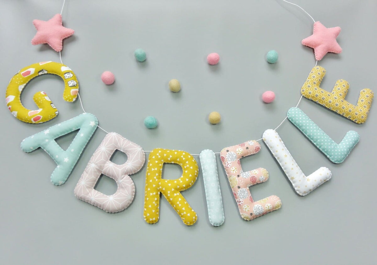 Guirlande prénom en tissu pastel menthe, moutarde et rose avec étoiles et pompons, exemple « Gabrielle »